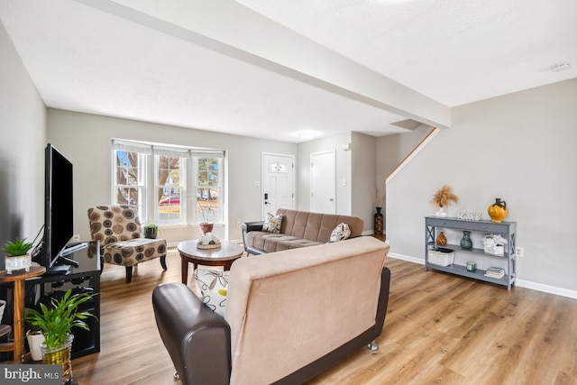 living area with baseboards and wood finished floors