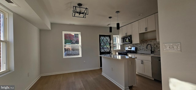 kitchen with a kitchen island, white cabinetry, appliances with stainless steel finishes, and sink