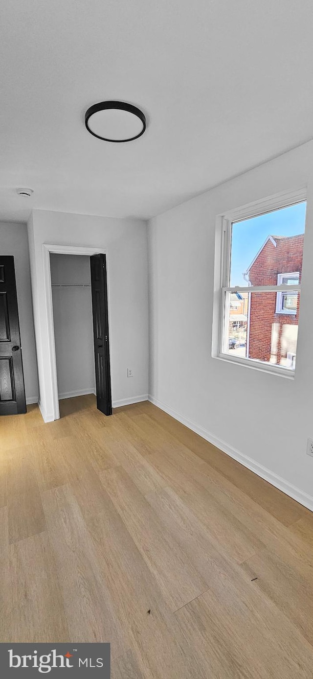 unfurnished bedroom featuring light hardwood / wood-style floors and a closet