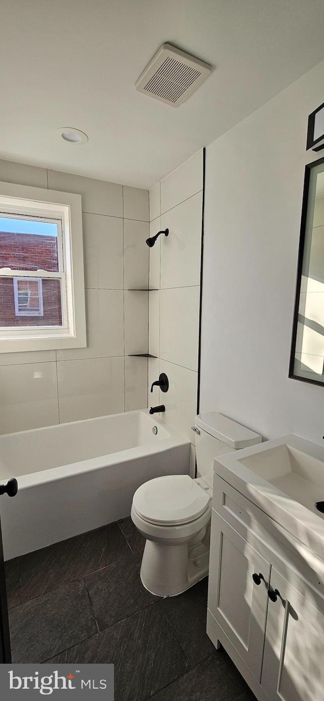 full bathroom with vanity, toilet, and tiled shower / bath combo