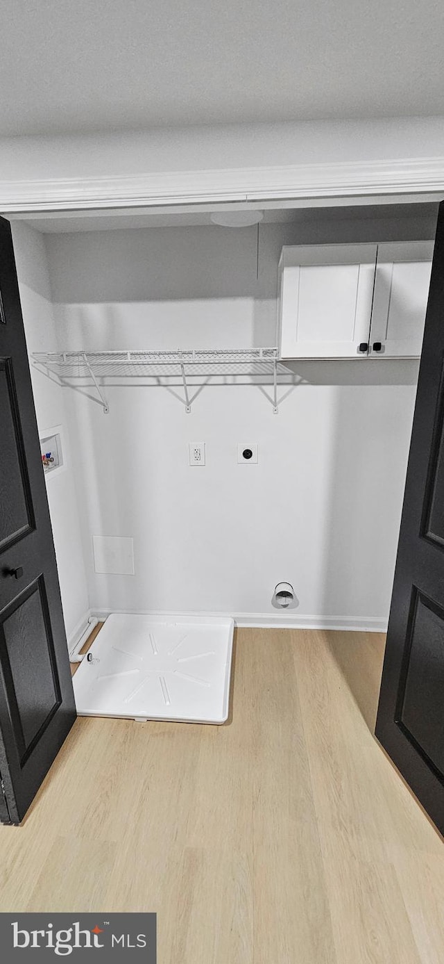 laundry room featuring washer hookup, electric dryer hookup, light hardwood / wood-style flooring, and cabinets