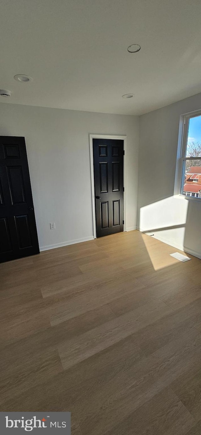 unfurnished room featuring hardwood / wood-style flooring