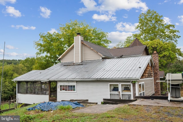 rear view of property with a sunroom