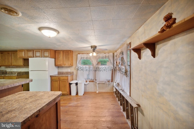 kitchen featuring white refrigerator, ceiling fan, and light hardwood / wood-style flooring