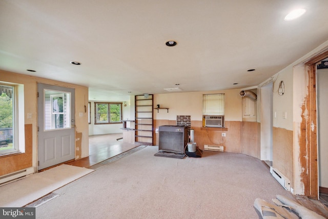 unfurnished living room featuring cooling unit, a baseboard radiator, light colored carpet, and a wood stove