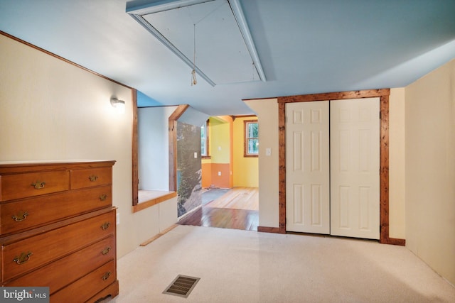 unfurnished bedroom with light colored carpet and a closet