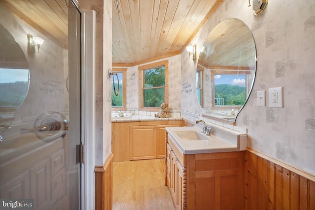 bathroom with hardwood / wood-style flooring, vanity, wooden walls, and wooden ceiling