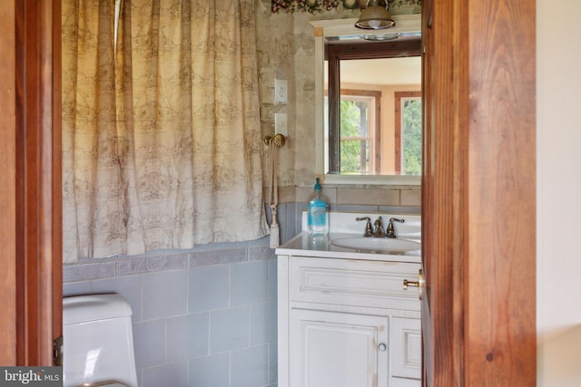 bathroom with vanity and tile walls