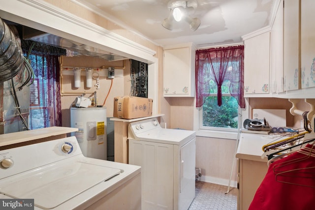 clothes washing area featuring water heater, cabinets, and washer and clothes dryer