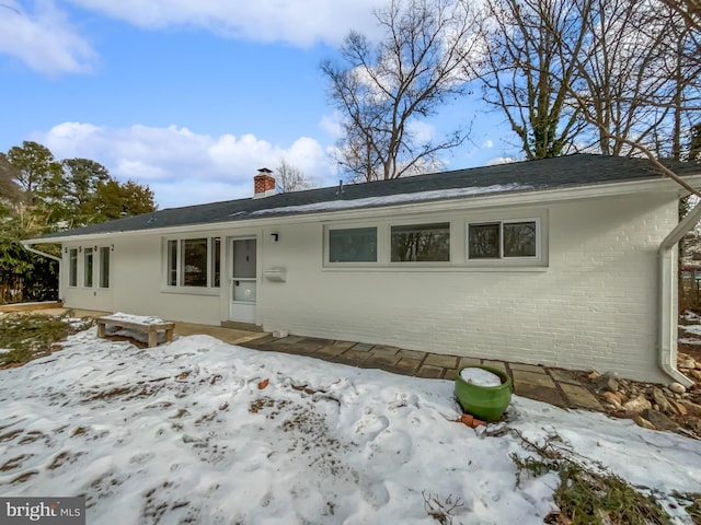 view of snow covered back of property