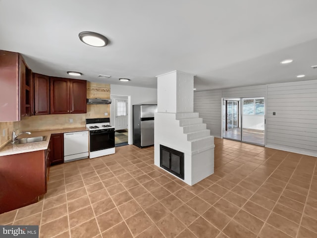 kitchen with sink, range with gas cooktop, light tile patterned floors, stainless steel refrigerator, and dishwasher