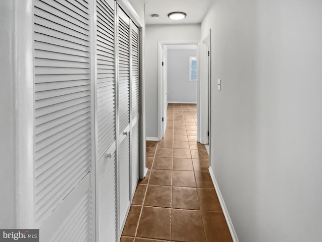 hallway with dark tile patterned flooring