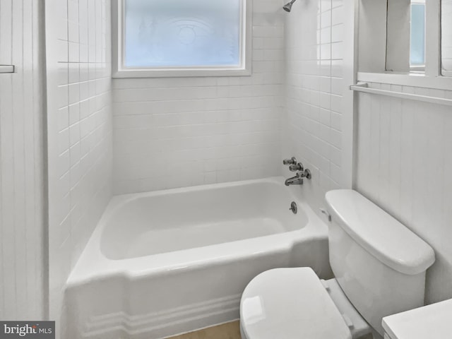 bathroom featuring toilet and tiled shower / bath combo