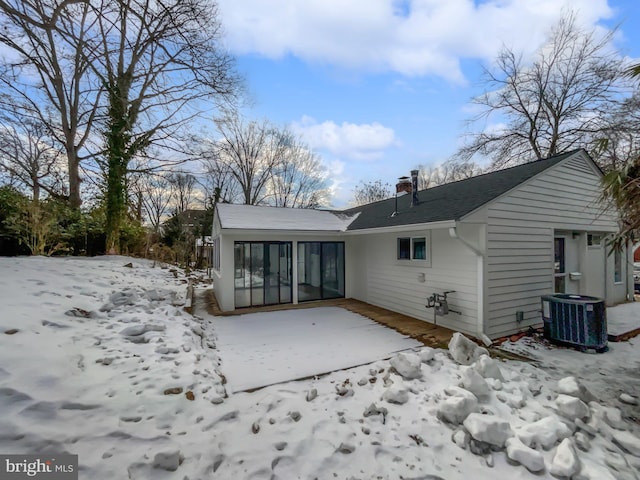 snow covered property featuring central AC unit