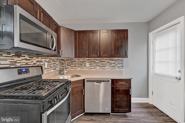 kitchen with dark brown cabinetry, sink, tasteful backsplash, appliances with stainless steel finishes, and dark hardwood / wood-style floors