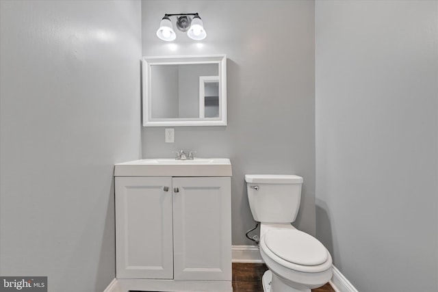 bathroom featuring vanity, hardwood / wood-style floors, and toilet