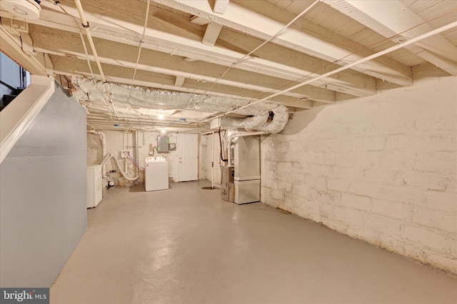 basement with heating unit, electric panel, and washer and clothes dryer