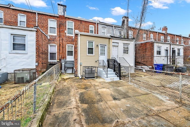 rear view of property with central AC