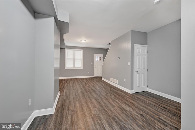 unfurnished living room featuring dark wood-type flooring