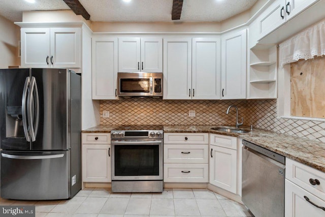 kitchen with tasteful backsplash, white cabinetry, sink, light stone counters, and stainless steel appliances