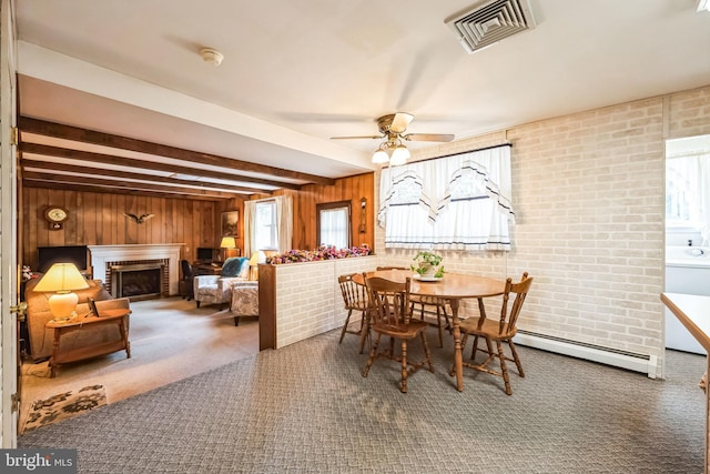 dining room featuring a fireplace, wood walls, carpet flooring, baseboard heating, and beam ceiling