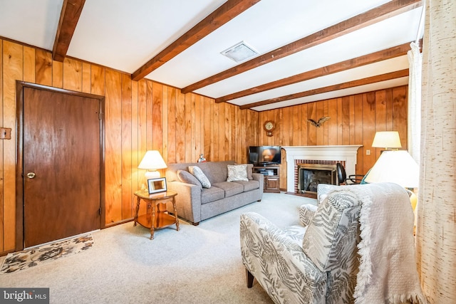 carpeted living room featuring beam ceiling, a fireplace, and wood walls