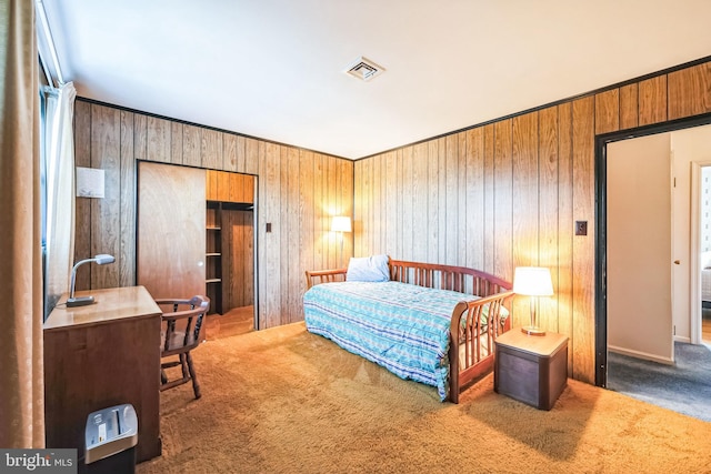 bedroom with carpet floors and wood walls