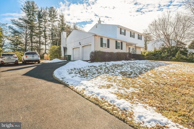 snow covered property featuring a garage