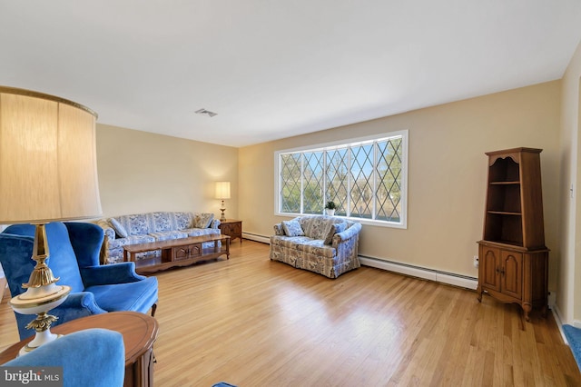 living room featuring wood-type flooring and a baseboard heating unit