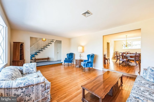 living room with wood-type flooring and a notable chandelier