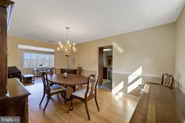 dining area featuring a chandelier and light wood-type flooring