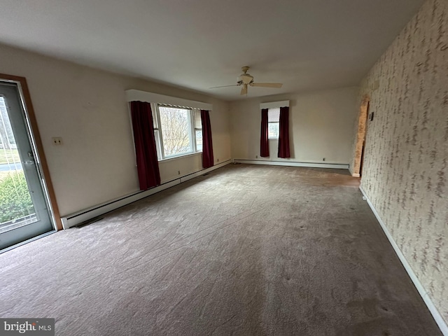 carpeted empty room featuring baseboard heating and ceiling fan