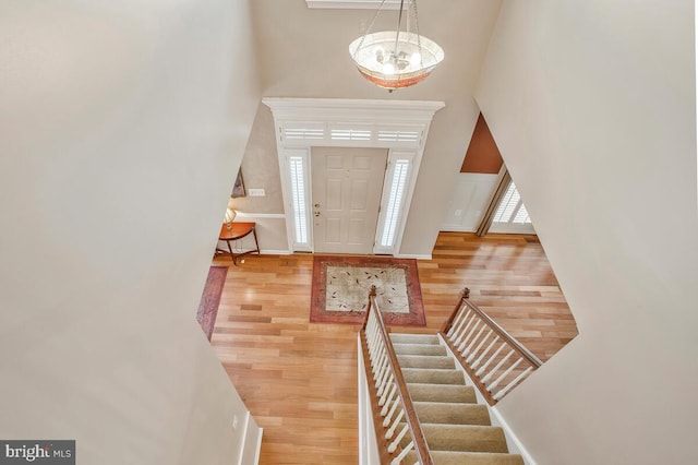 foyer entrance with a high ceiling, a chandelier, and light hardwood / wood-style floors