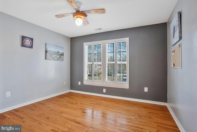 empty room with ceiling fan and light hardwood / wood-style flooring