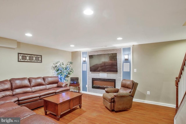 living room featuring a large fireplace and light wood-type flooring