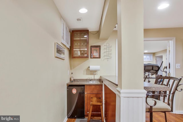 bar featuring fridge and hardwood / wood-style flooring