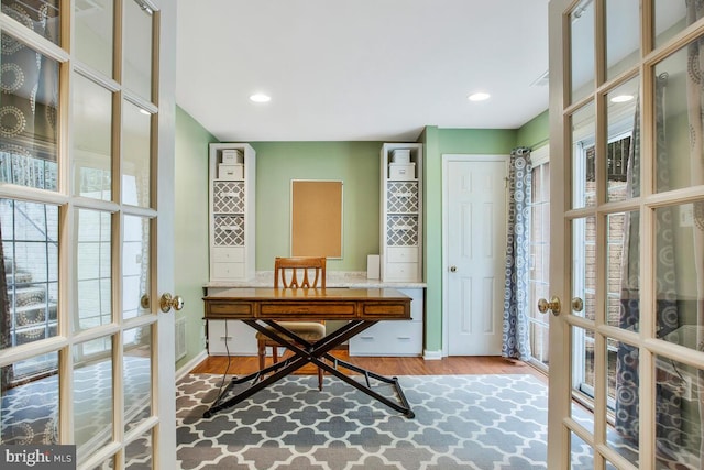 office with wood-type flooring and french doors