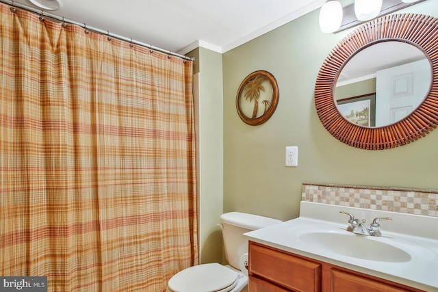 bathroom with ornamental molding, vanity, and toilet