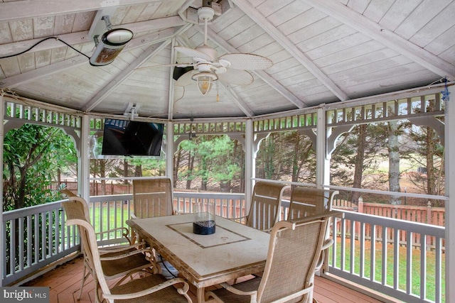 sunroom / solarium featuring vaulted ceiling with beams, wood ceiling, and ceiling fan