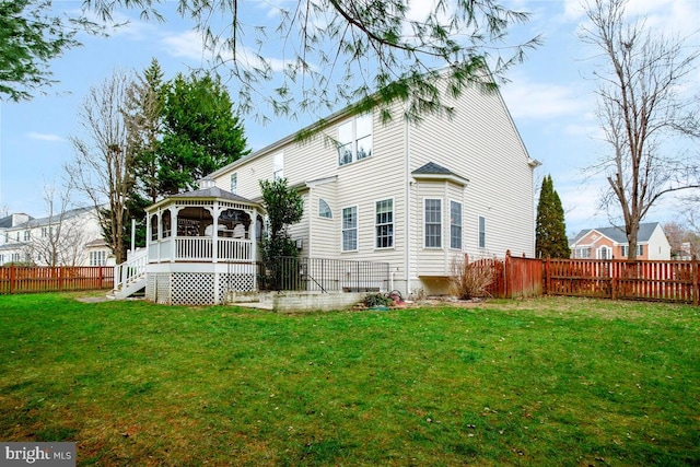 rear view of property featuring a gazebo and a yard