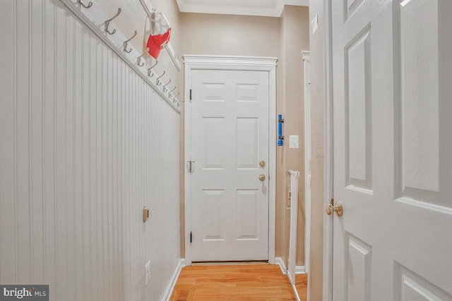 entryway featuring ornamental molding and light hardwood / wood-style floors