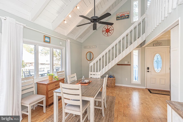 dining room featuring high vaulted ceiling, light hardwood / wood-style flooring, wooden ceiling, and beamed ceiling