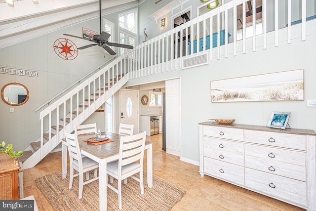 dining area with ceiling fan and high vaulted ceiling