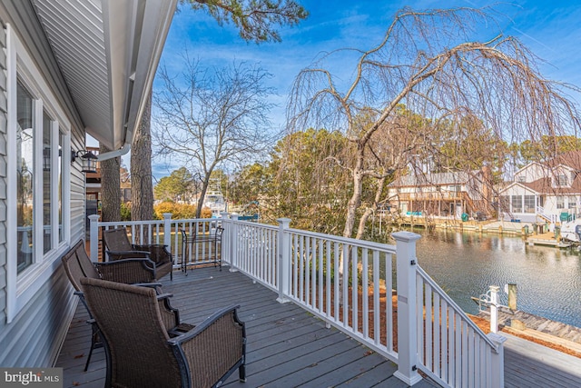 wooden terrace featuring a water view and a boat dock