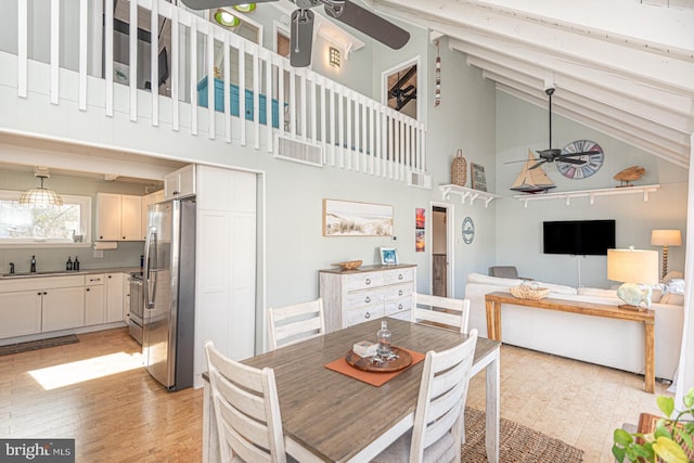 dining space featuring beamed ceiling, high vaulted ceiling, sink, and ceiling fan