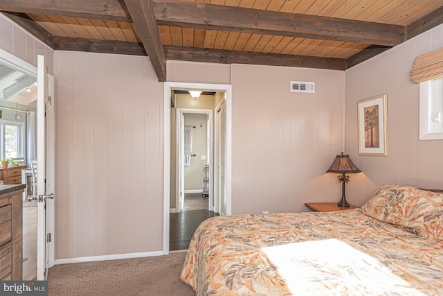 carpeted bedroom featuring wood ceiling and beam ceiling