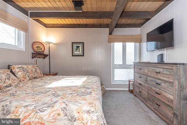 bedroom featuring beamed ceiling, wood ceiling, and carpet floors