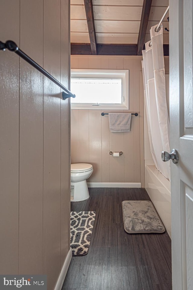 bathroom with beamed ceiling, wood-type flooring, wood ceiling, toilet, and shower / bathtub combination with curtain