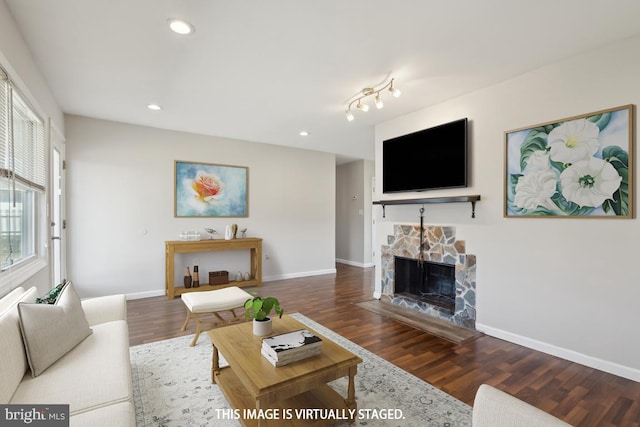 living room featuring recessed lighting, a fireplace, baseboards, and wood finished floors