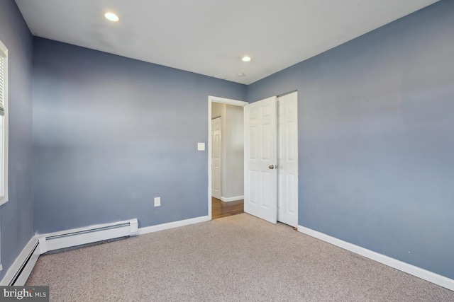 empty room with carpet flooring, recessed lighting, a baseboard heating unit, and baseboards